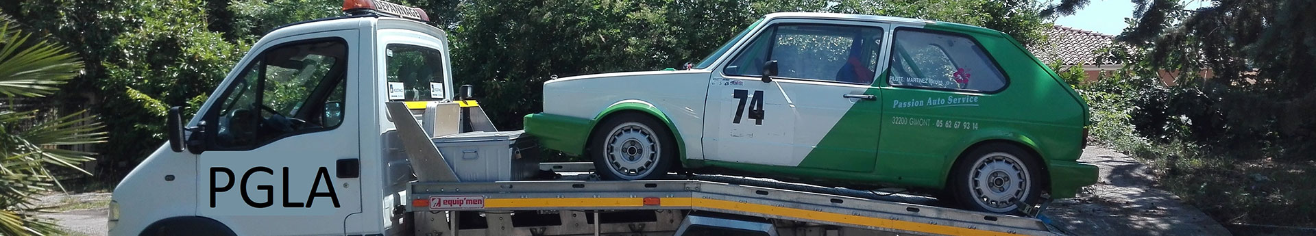 Dépanneuse pgla-garage-lussan transportant une voiture de course à Lussan dans un quartier résidentiel verdoyant