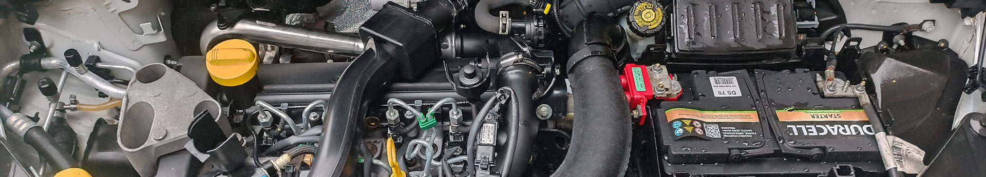 Compartiment moteur propre chez pgla-garage-lussan à Lussan avec batterie Duracell et composants mécaniques visibles